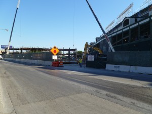Looking at the third base side exterior of Wrigley Field along Clark Street. Towering upwards from street level is the skeleton of the future offices for the ballclub. When finished, they will rise 6 stories high.